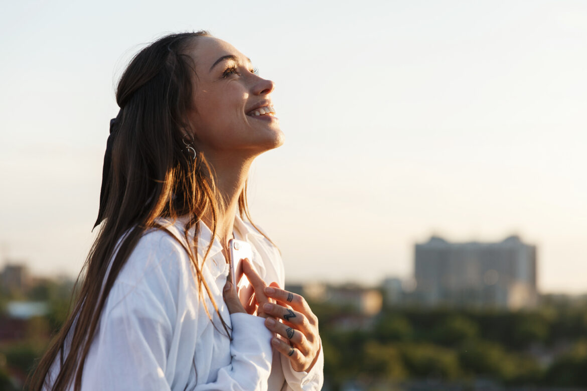 Beautiful young woman smiles tender standing on the rooftop in t