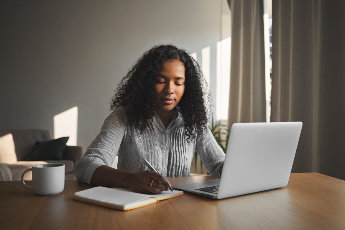Beautiful mixed race student girl with voluminous hairdo working