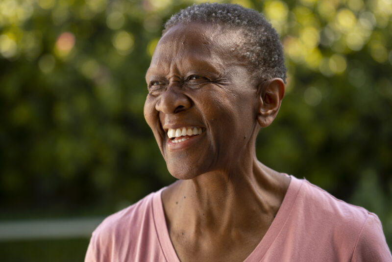 vista-lateral-mulher-sorridente-ao-ar-livre